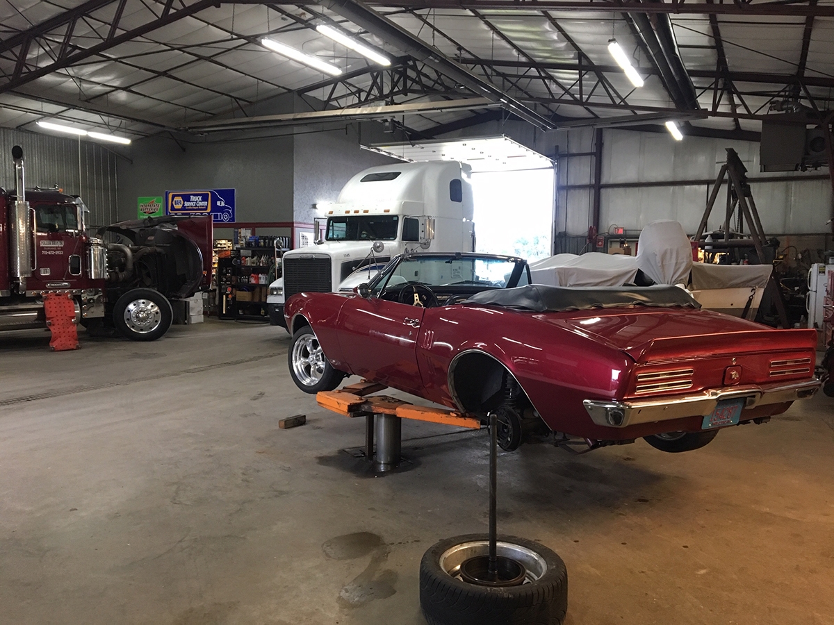 Polzer Brothers auto repair garage with semi trucks and convertible being worked on